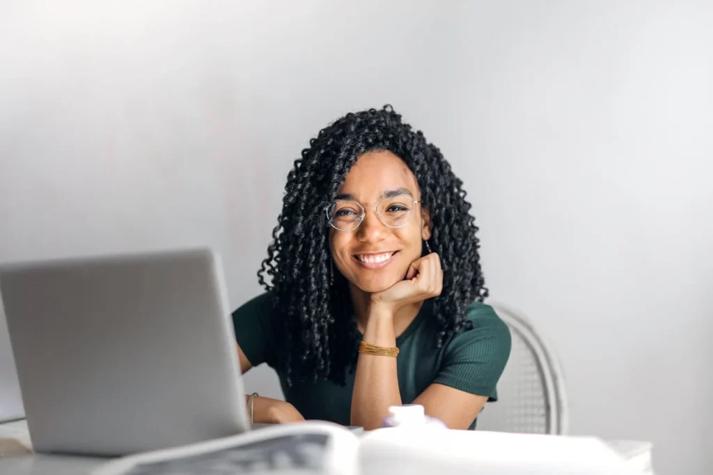Smiling young woman working on a laptop